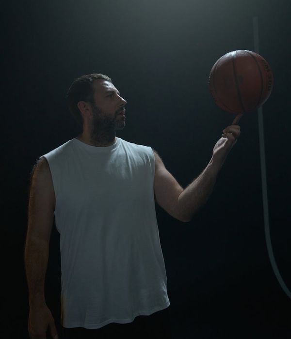 Person holding a balanced pose, showing strength and concentration against a dark background.